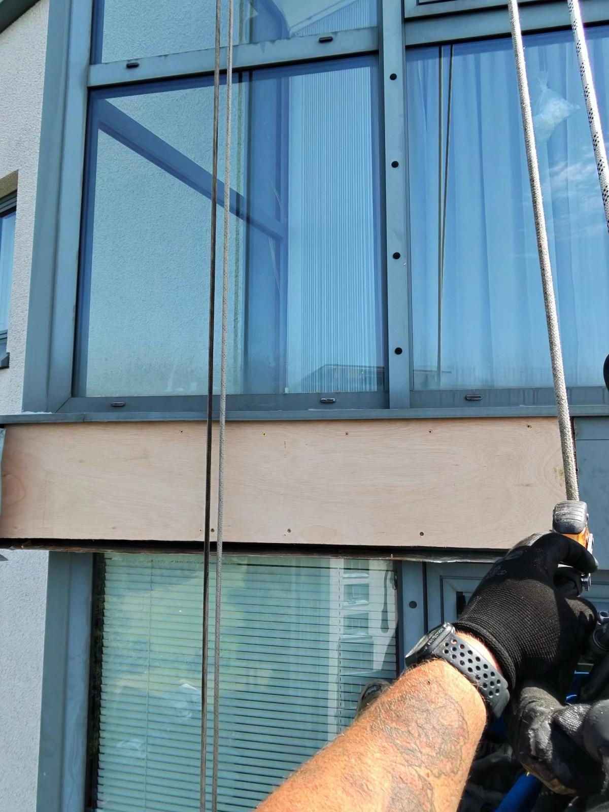 New plywood backing installed to replace severely deteriorated timber beneath high-rise residential window cladding in Newcastle, using specialist rope access techniques.