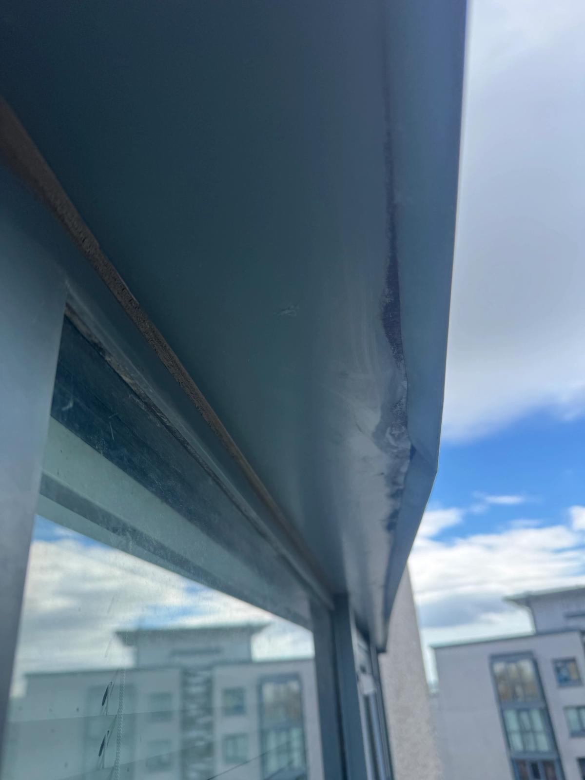 Close-up of deteriorated aluminium window flashing and sealant joints on a high-rise residential building in Newcastle, prior to rope access façade repairs.
