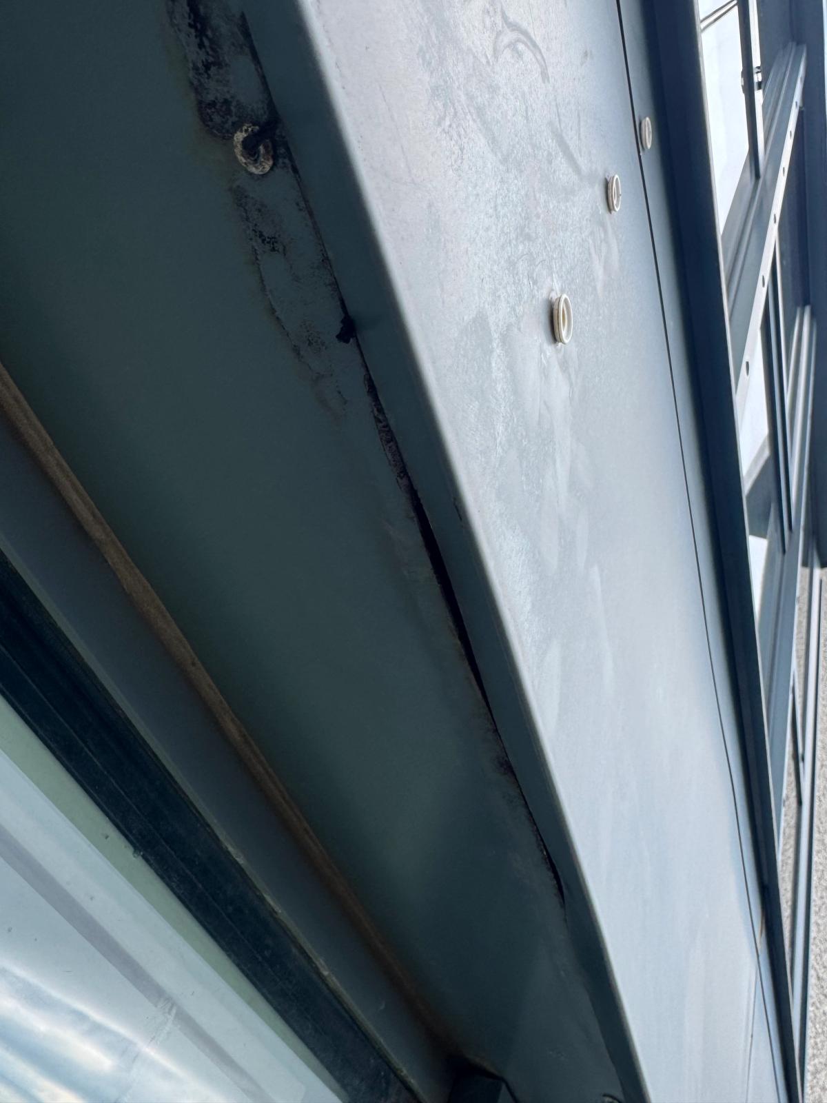 Deteriorated sealant joints and visible gaps beneath aluminium façade cladding on a high-rise residential building in Newcastle, before rope access repairs.