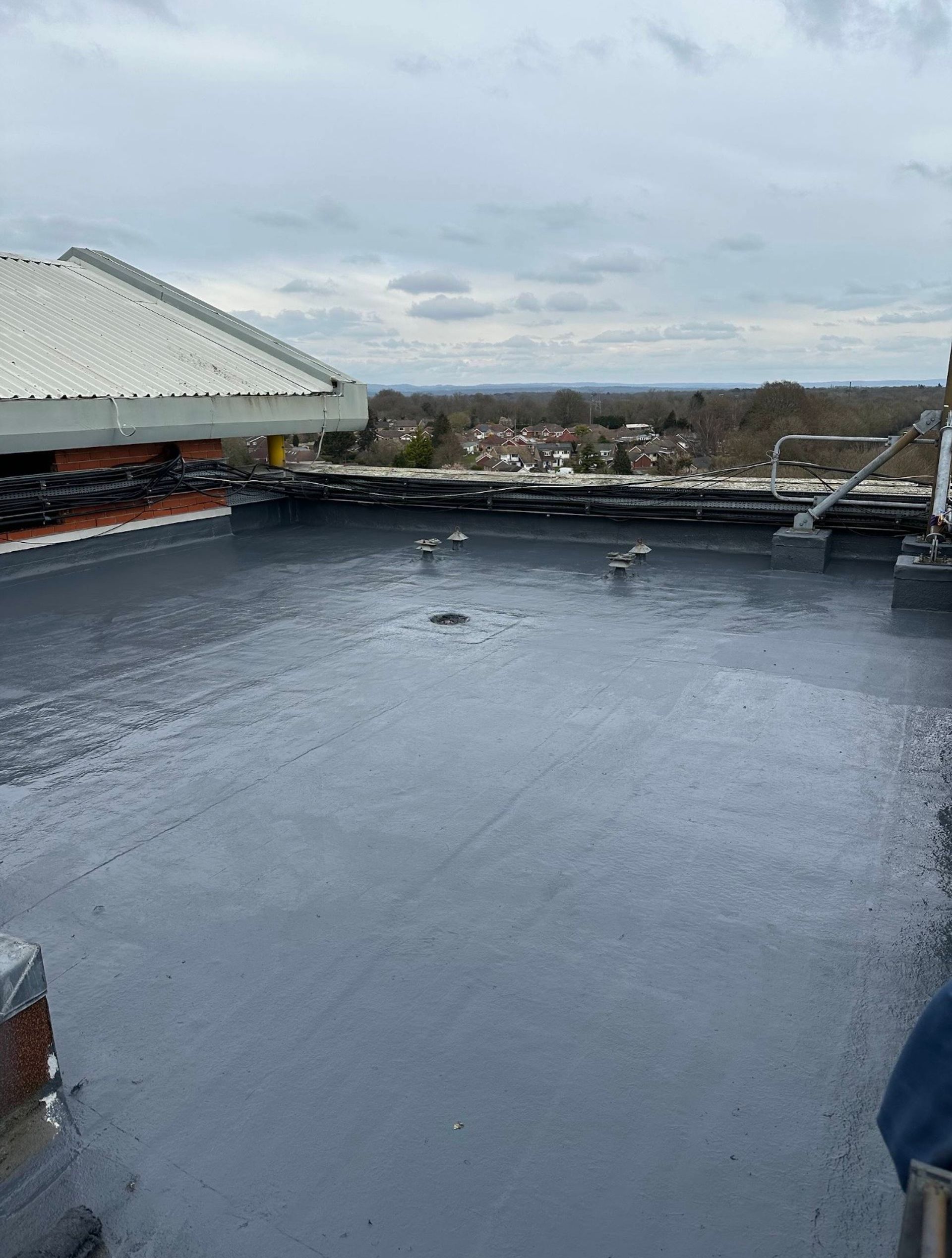 Completed liquid waterproofing system at Sandman Signature Gatwick, with the roof surface, upstands, outlets and perimeter details fully protected.