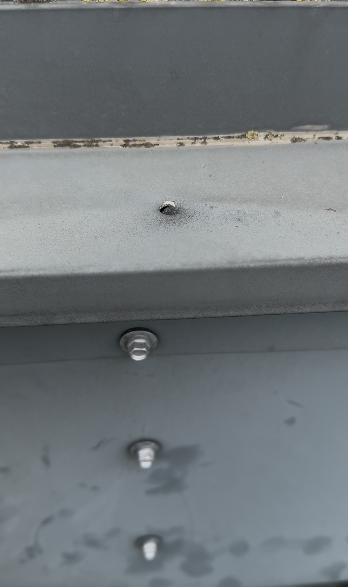 Close-up of aluminium façade cladding, mechanical fixings and deteriorated sealant along the window flashing on a high-rise residential building in Newcastle.