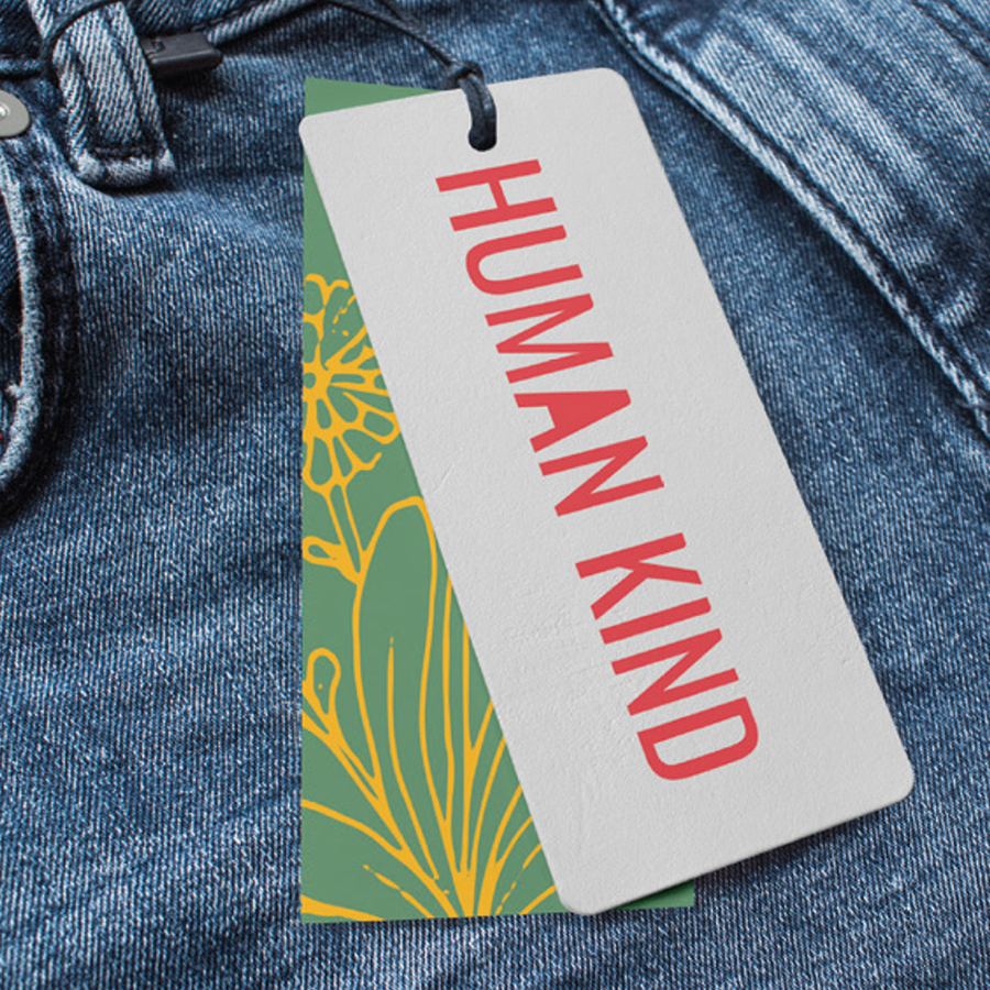 Label with the text "Human Kind" in orange sans-serif letters, attached to blue jeans.