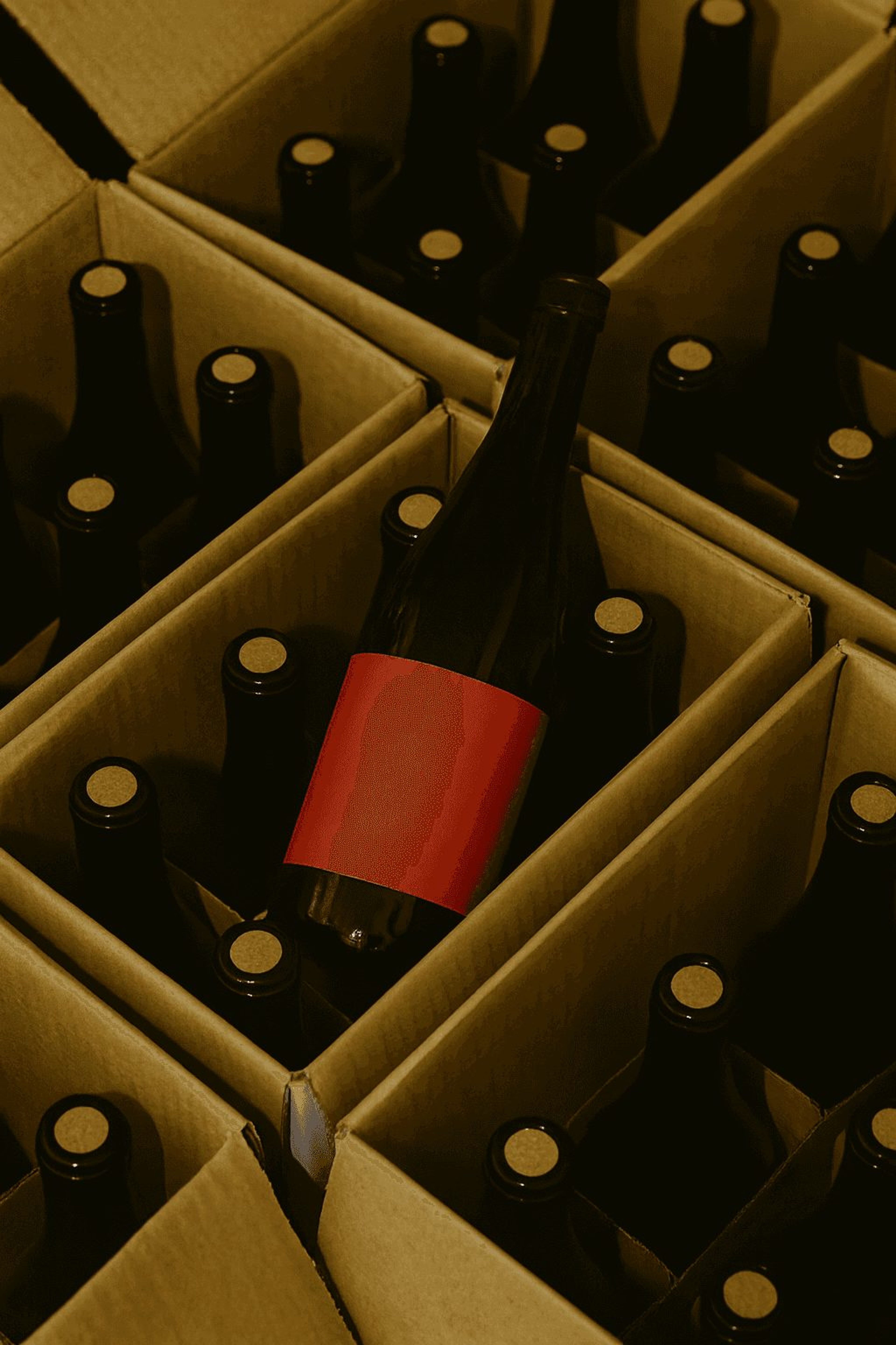 Bottle with a red label among cases of wine in cardboard boxes
