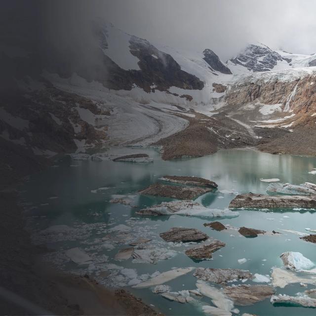 A glacial pond with mountains in the background
