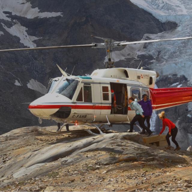 Helicopter landed in front of a glacier.