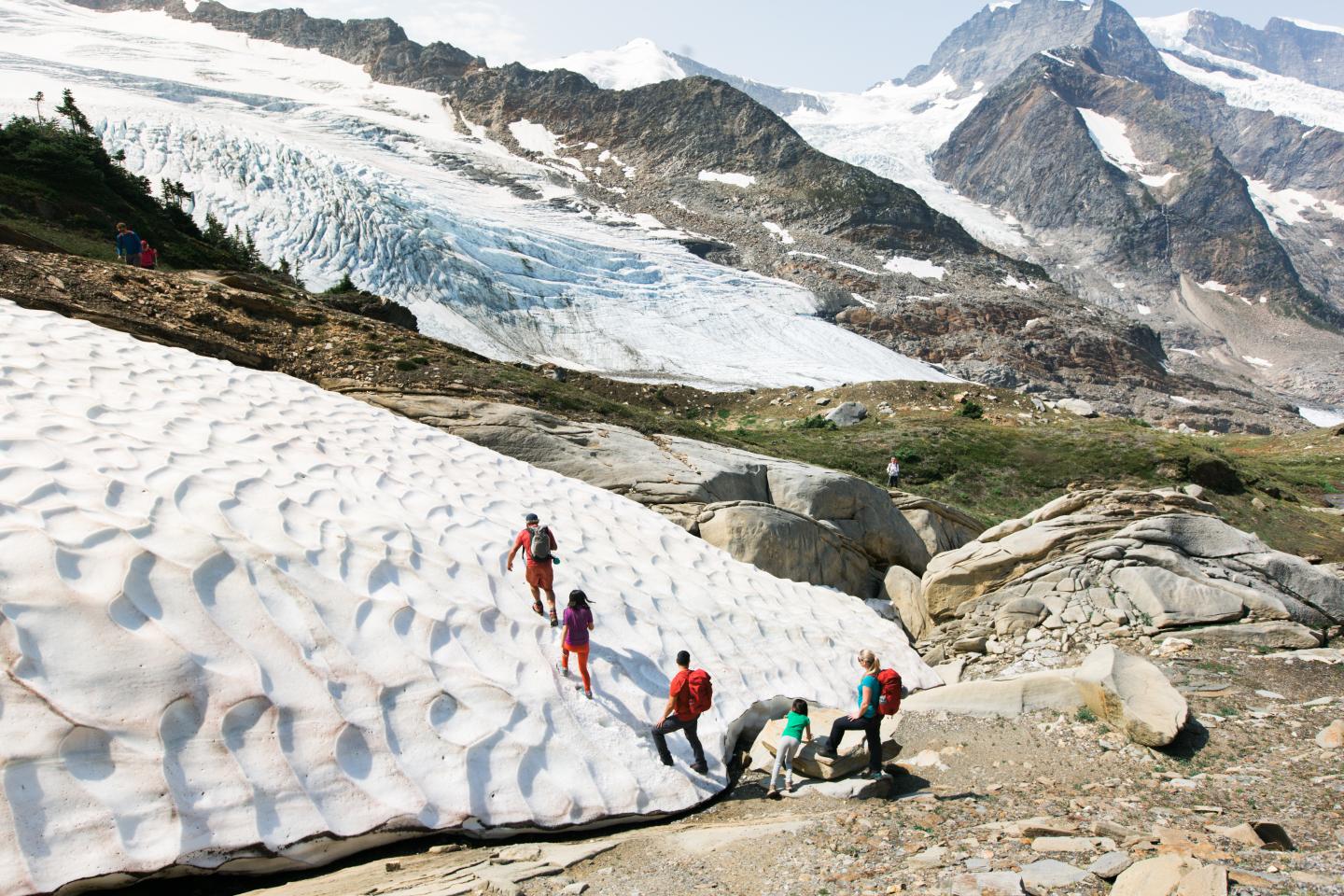 a group of people hiking onto a wavy rock formation