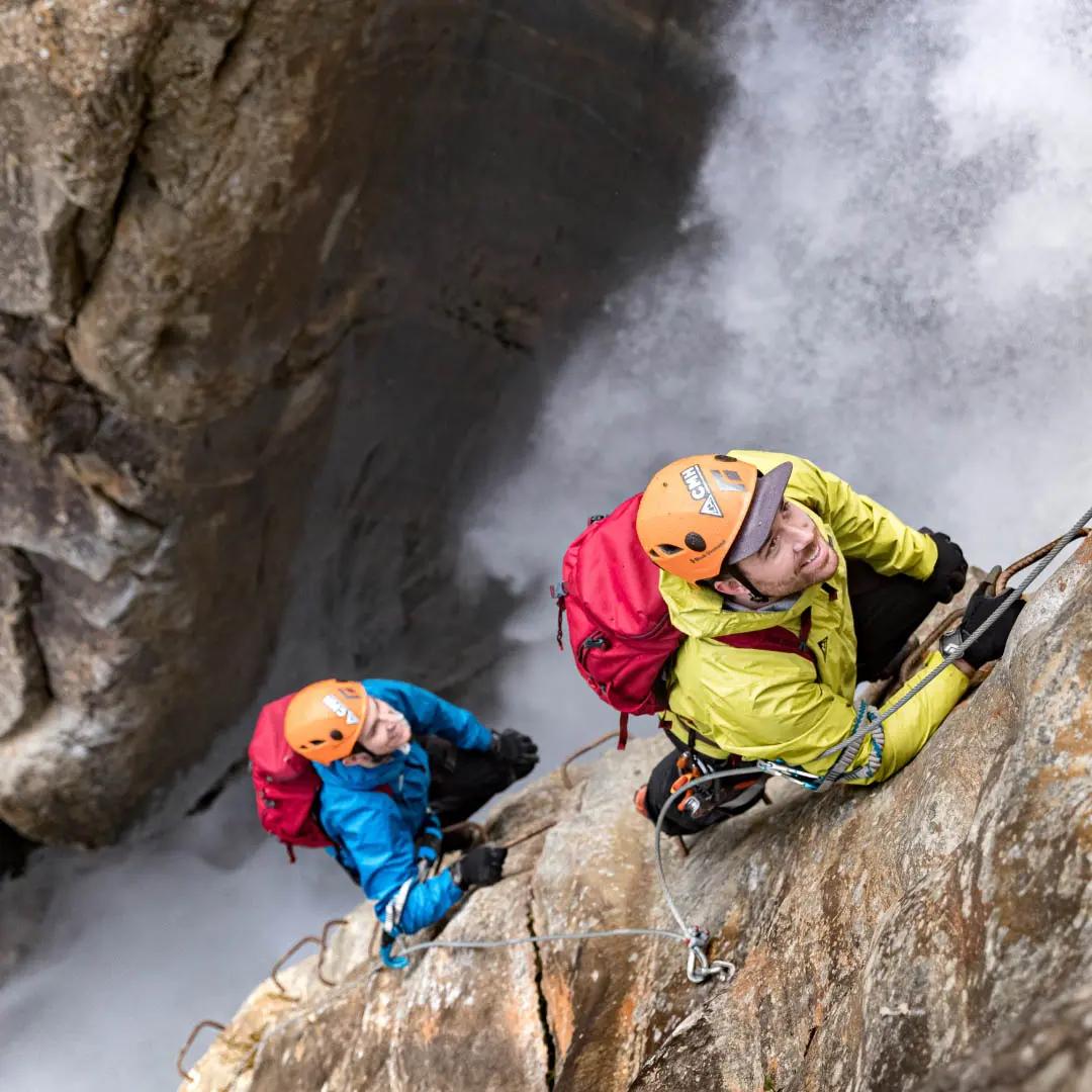 Two people climbing a via ferrata