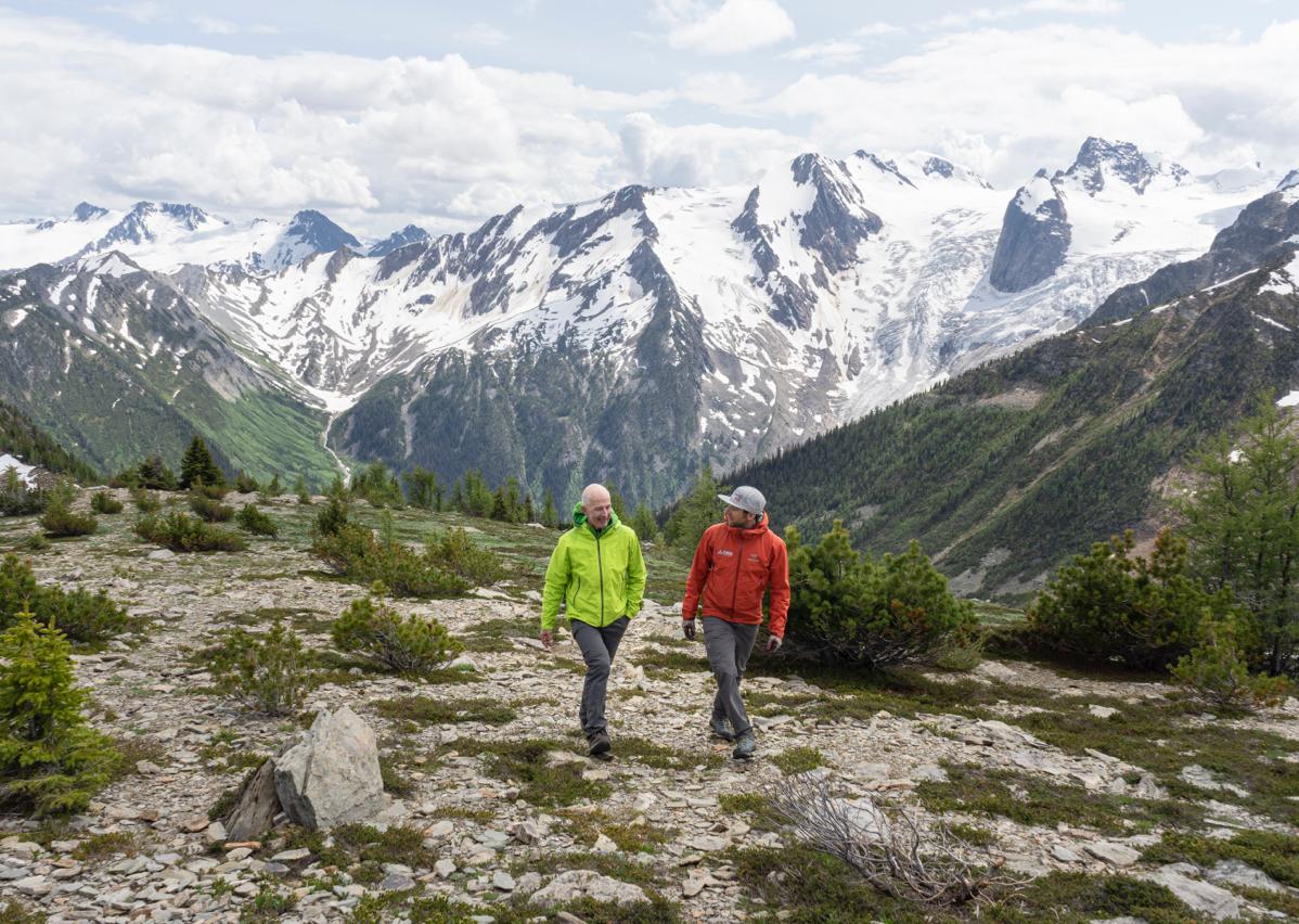 two people hiking with mountains in the background
