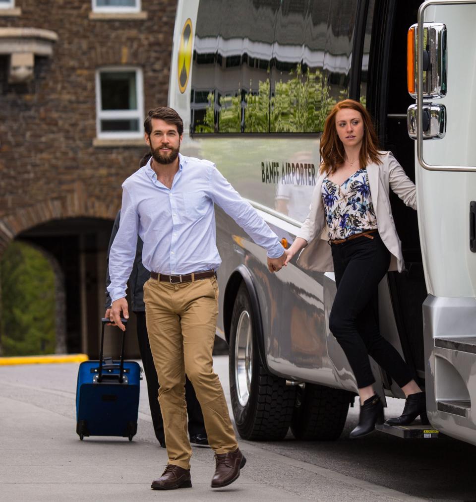 a man and a woman getting off of a shuttle bus