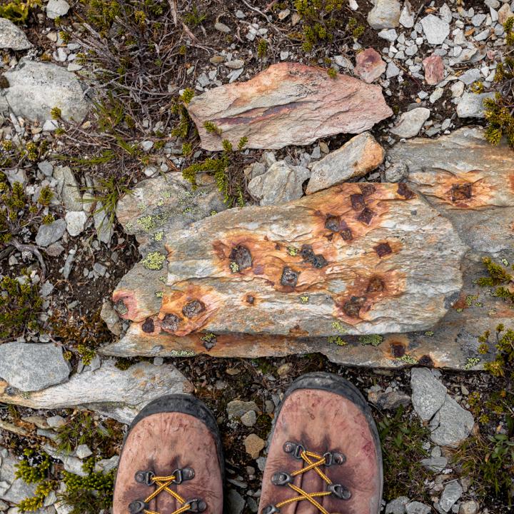 looking down at a set of hiking boots on rocks