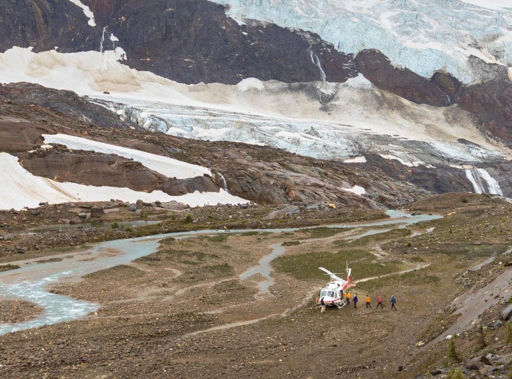 Helicopter landed nearby a glacial setting