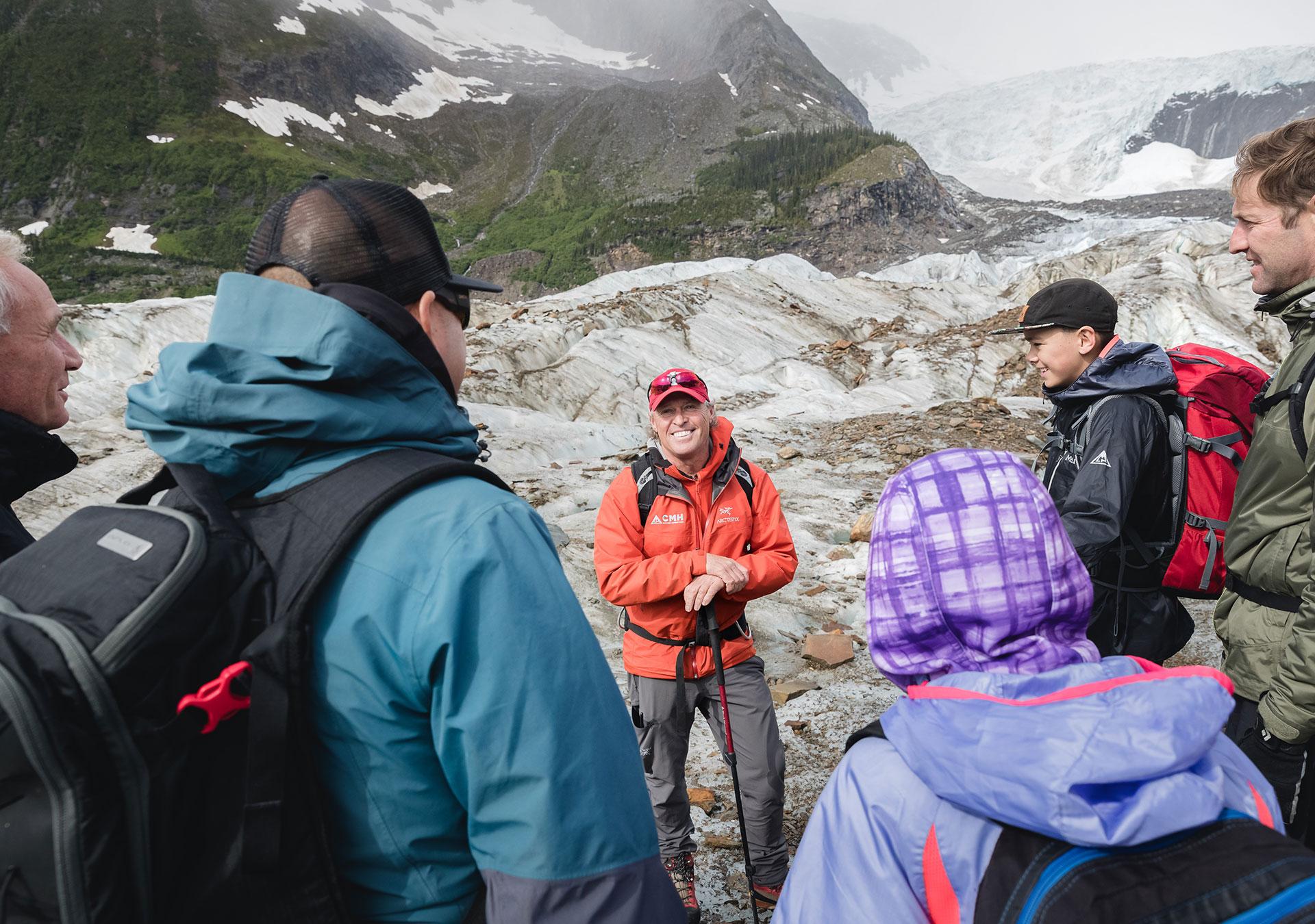 A guide stands in front of a group of guest hikers out in the field