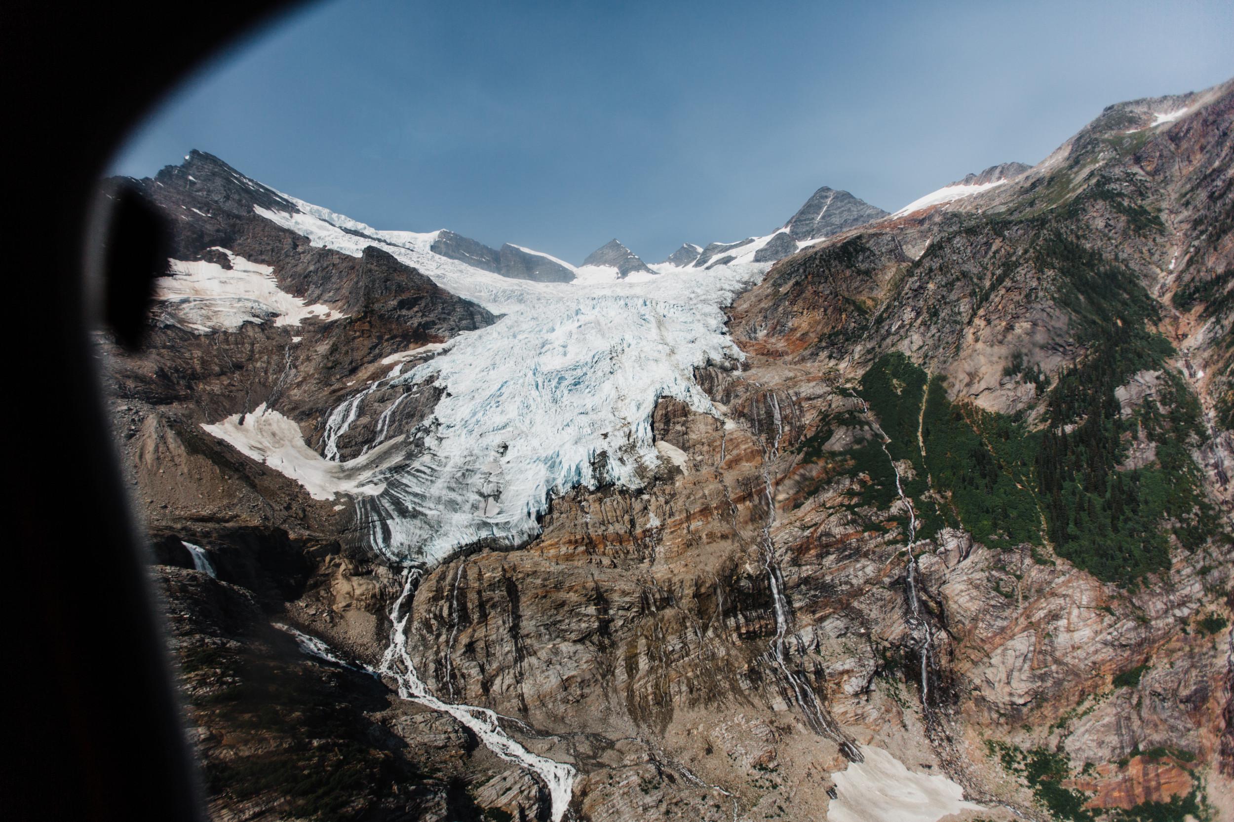 view of glacier framed through the window of a helicopter