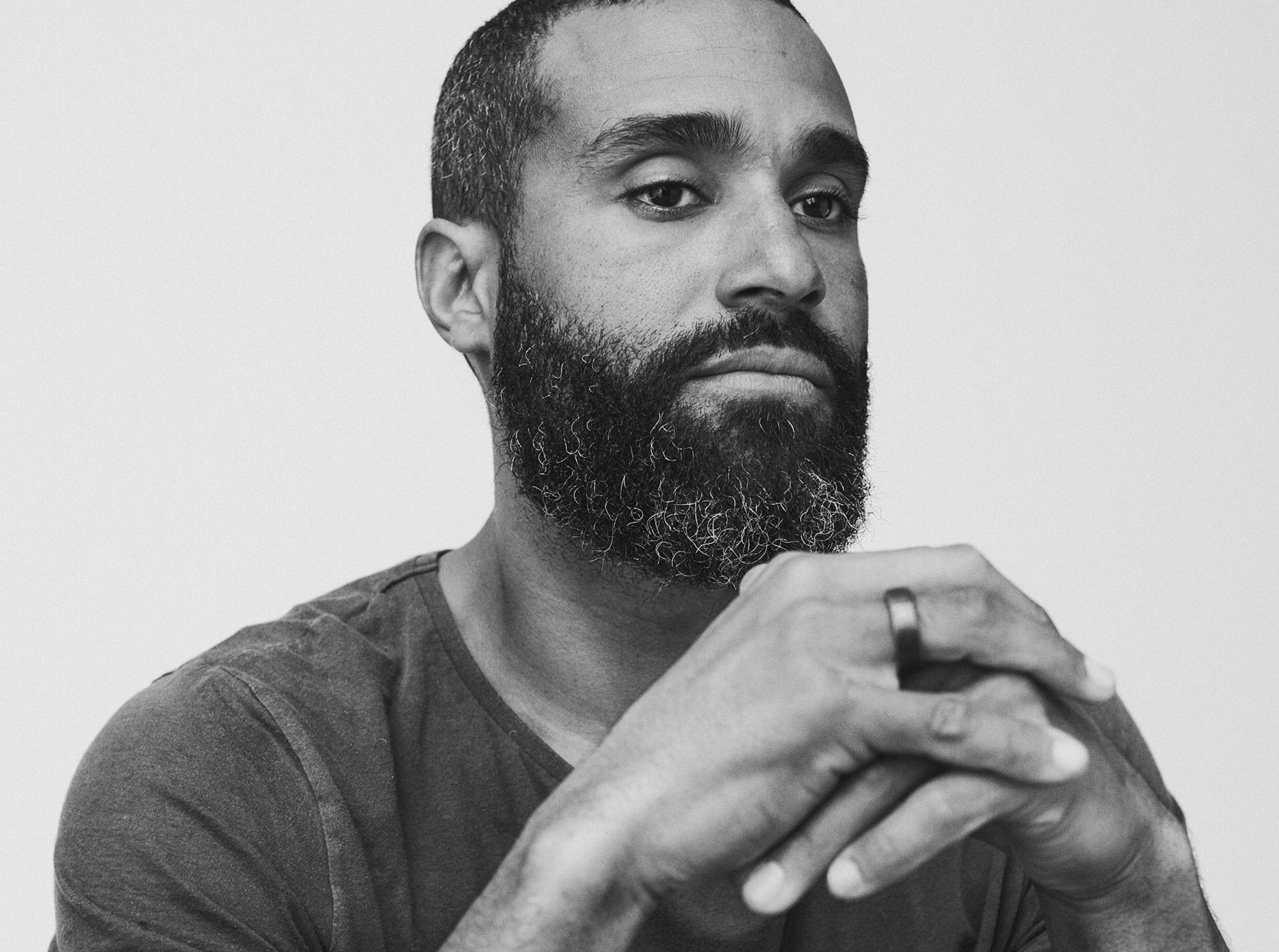 Svartvitt porträtt av Johnny Oduya med knäppta händer