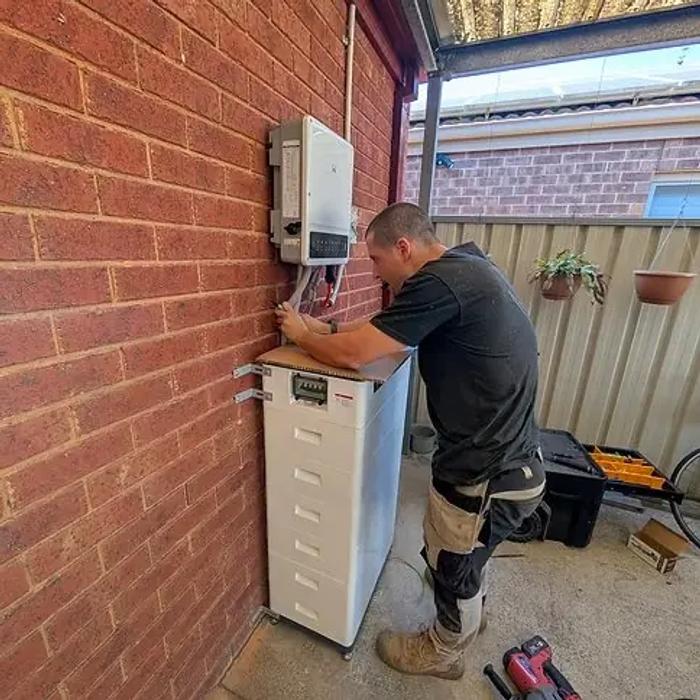 Home battery and inverter installed beside a switchboard