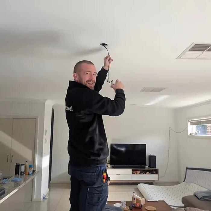 Electrician installing a downlight in a living room
