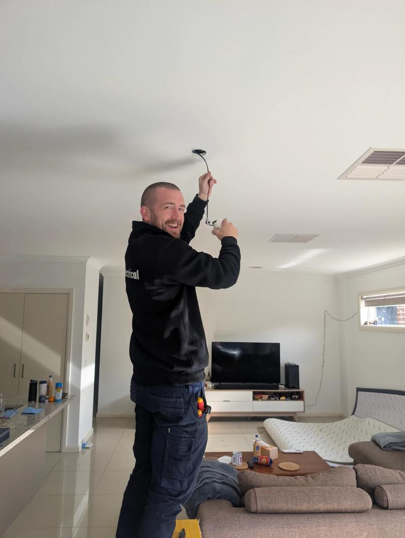Revelectrical electrician installing a downlight in a Melbourne living room