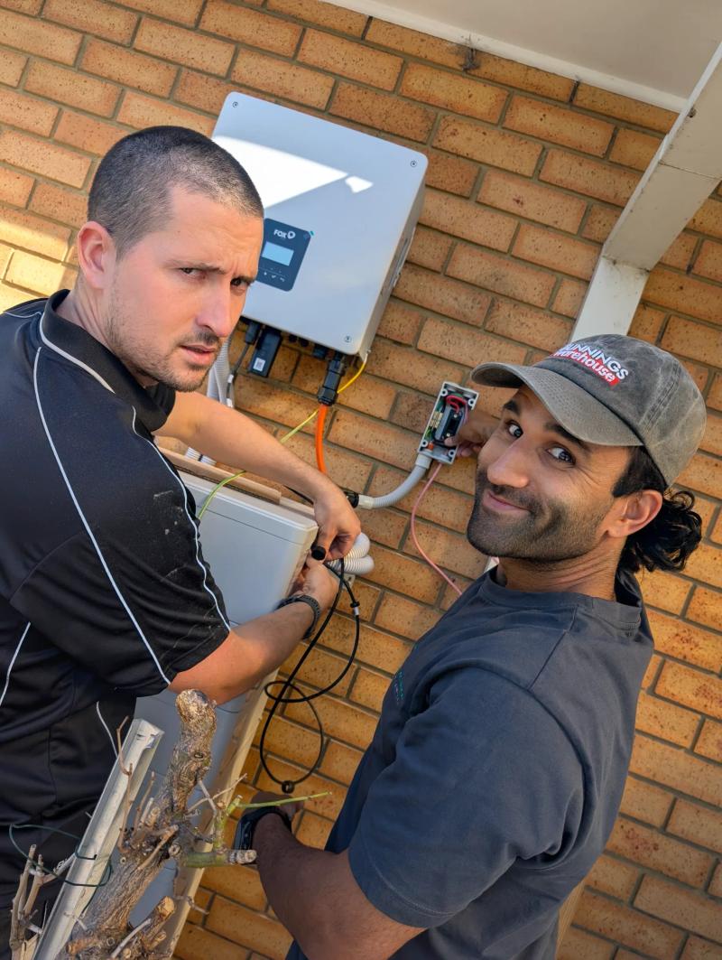 Two Revelectrical electricians working on an inverter at a Melbourne home