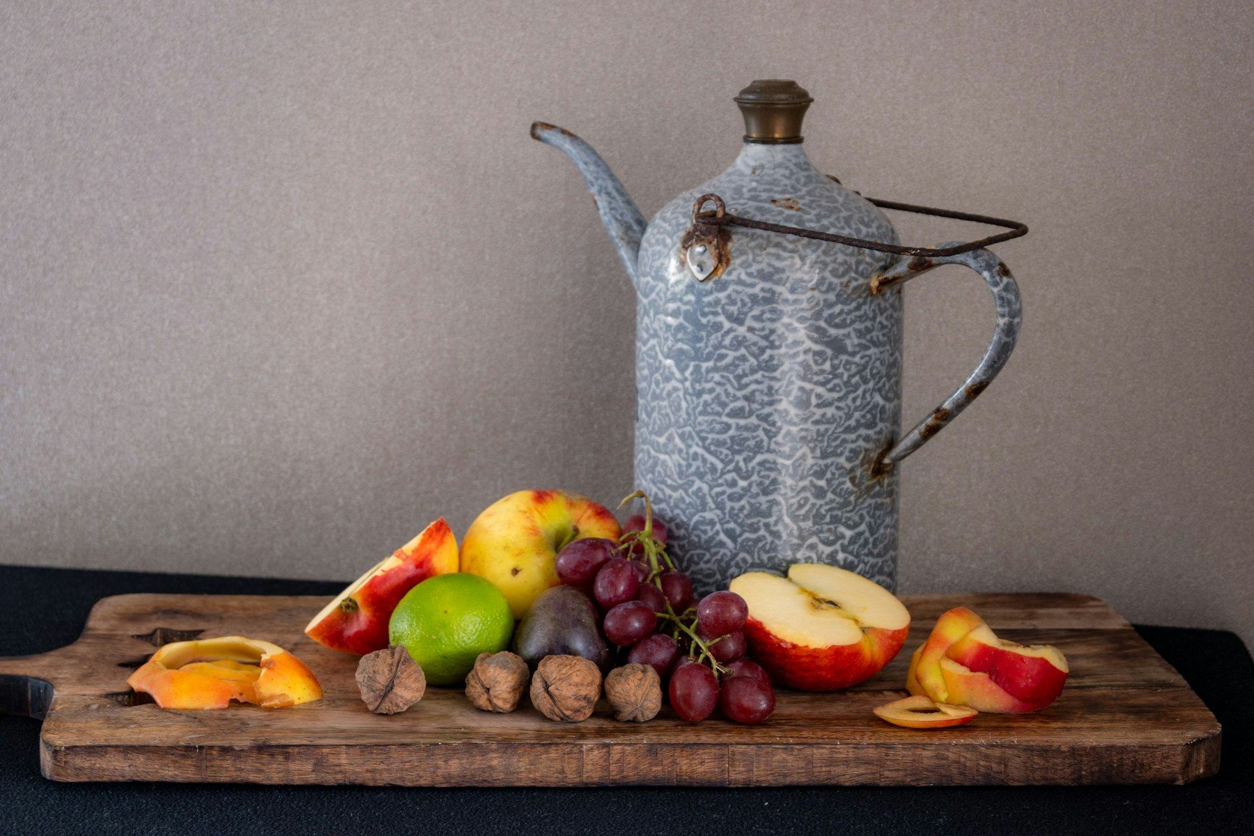 A table with fruits and a kettle