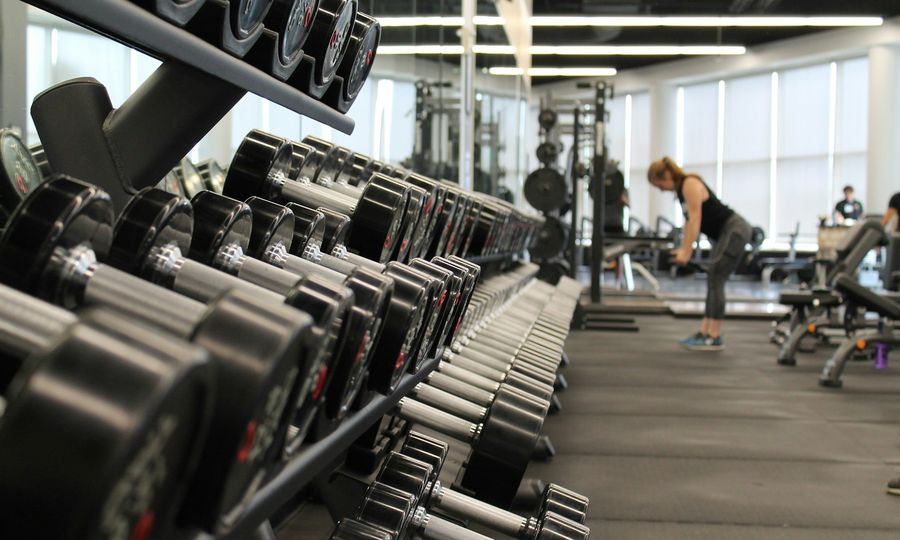 Woman standing surrounded by exercise equipment