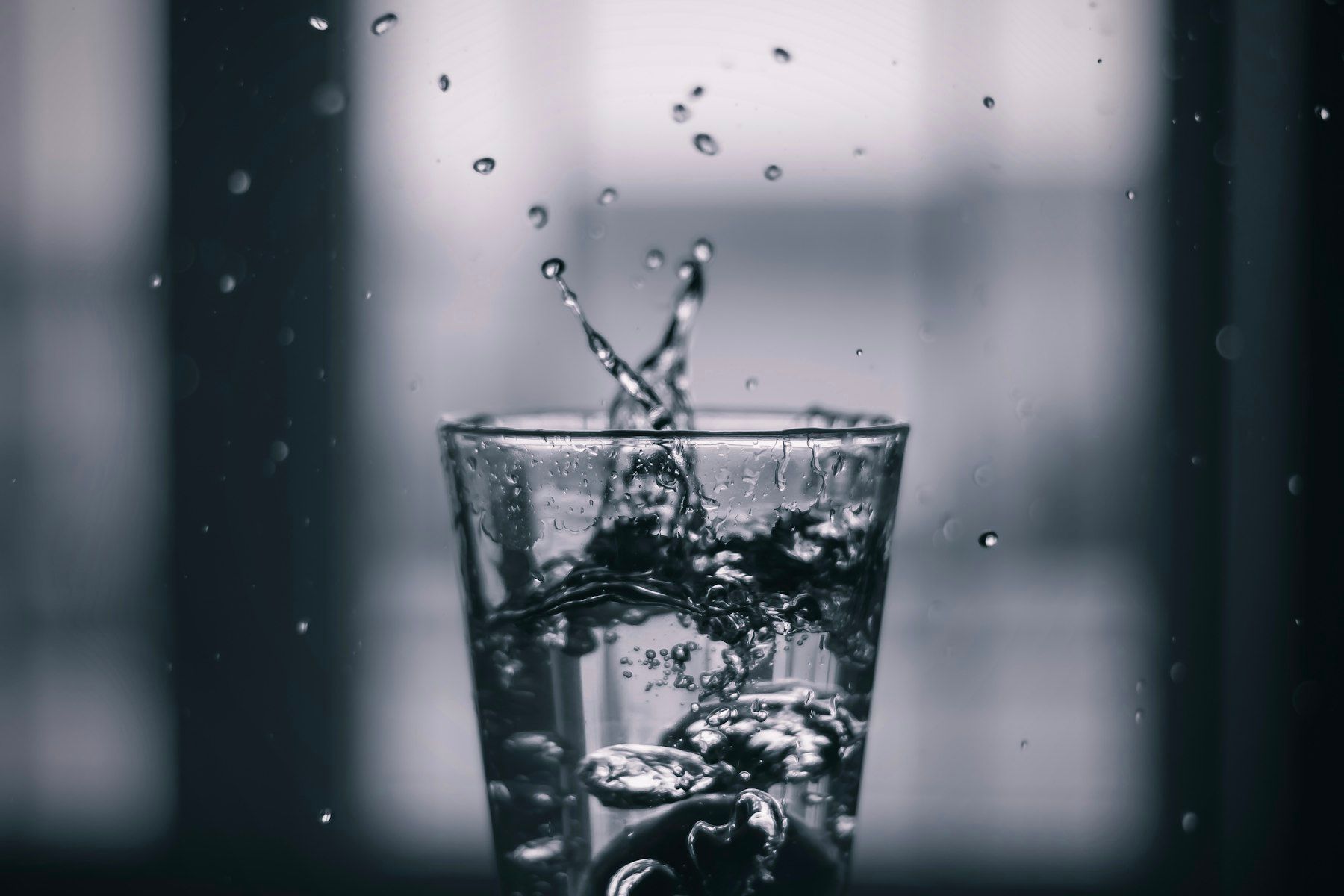 Water pouring on clear drinking glass