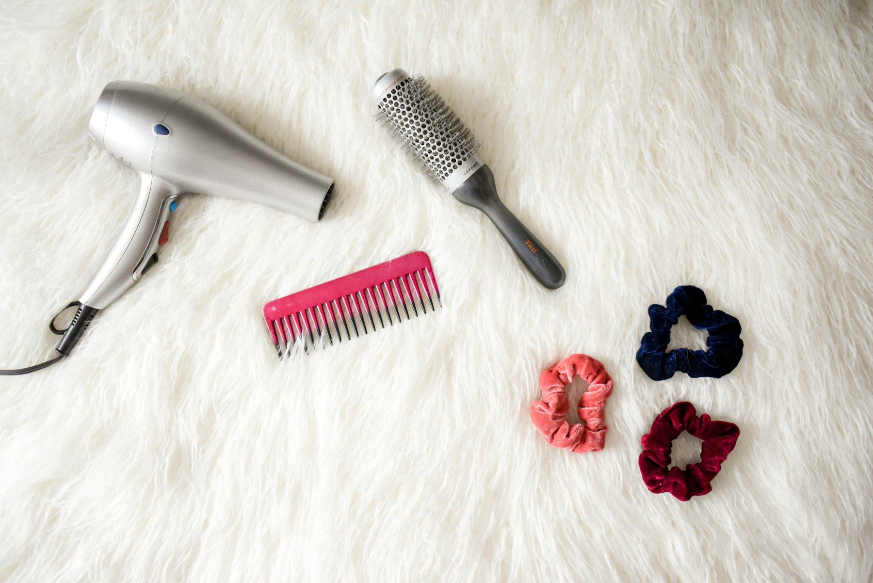 Gray corded hair dryer and red comb