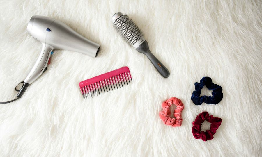 Gray corded hair dryer and red comb