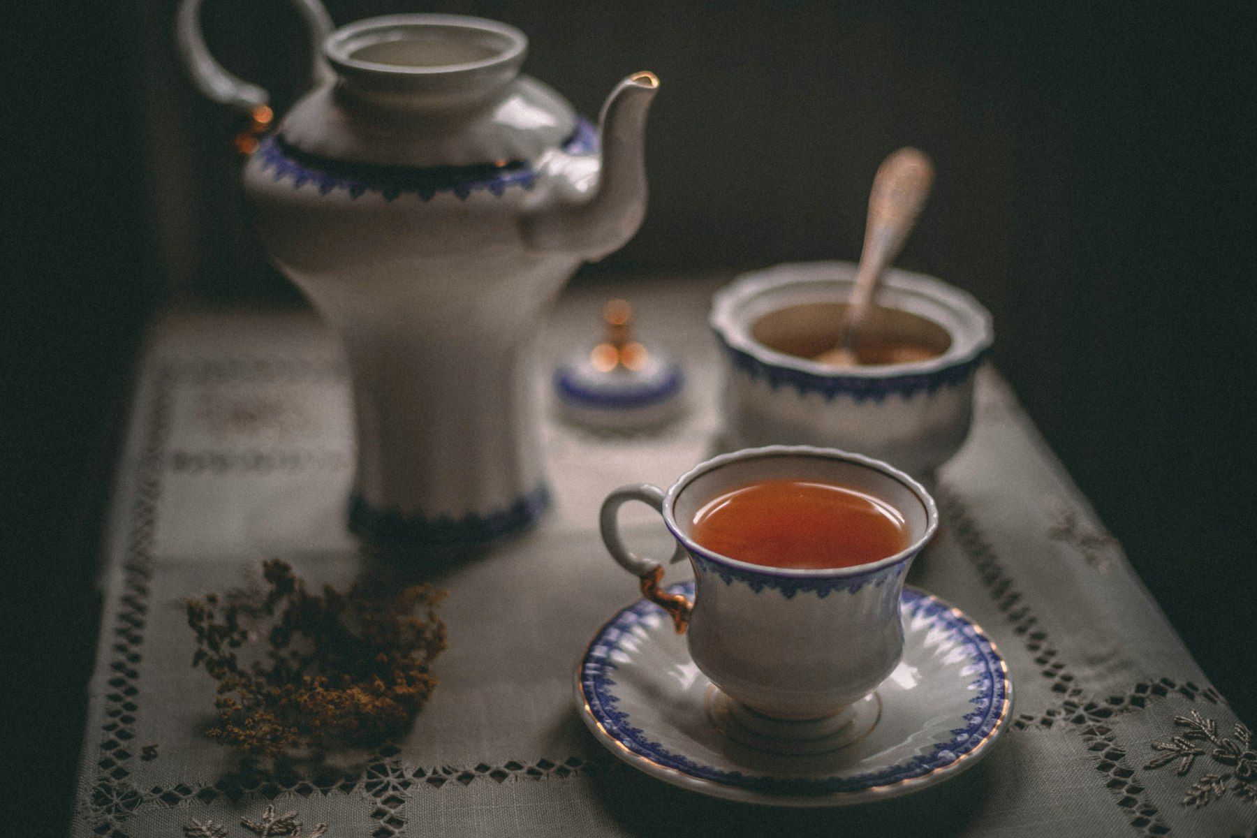 White ceramic teapot beside white ceramic teacup on saucer
