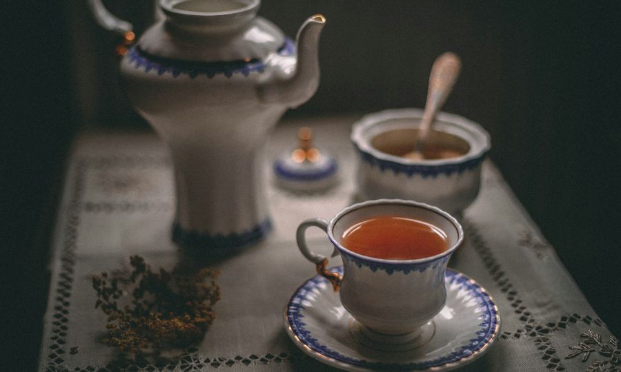 White ceramic teapot beside white ceramic teacup on saucer