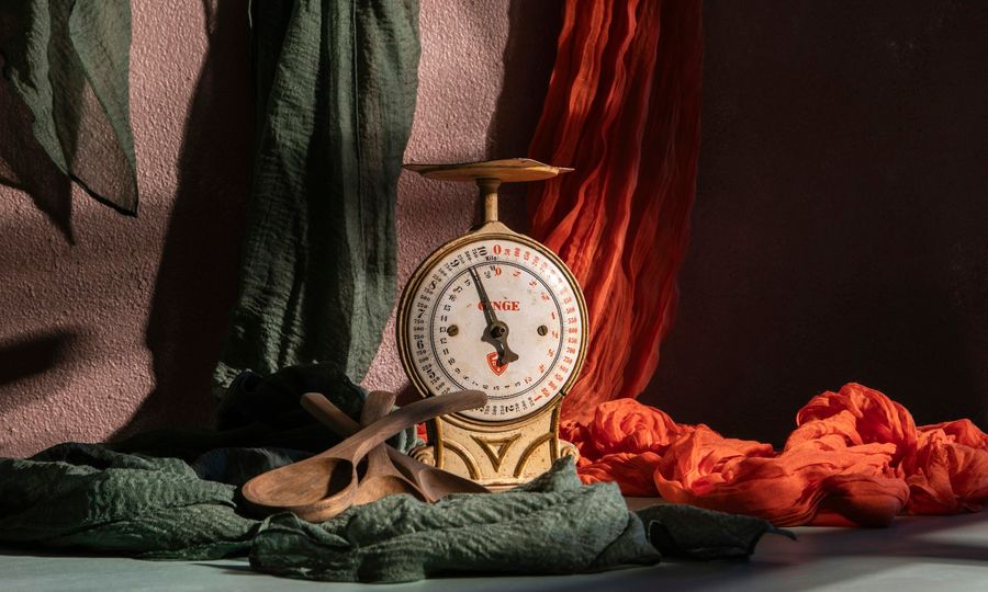 A vintage scale is posed with colorful fabrics