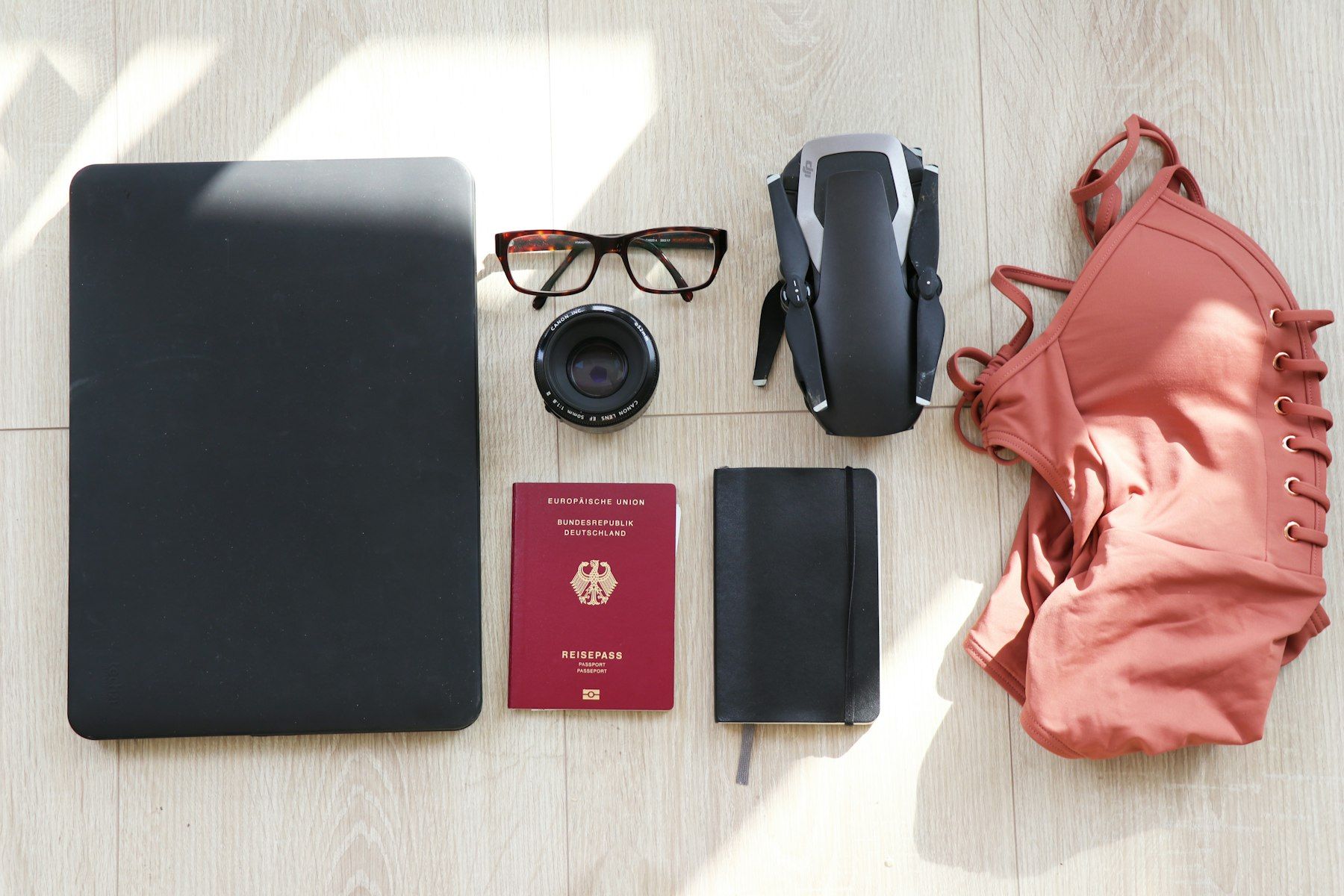 Laptop, eyeglasses, passport, notebook, drone and swimsuit