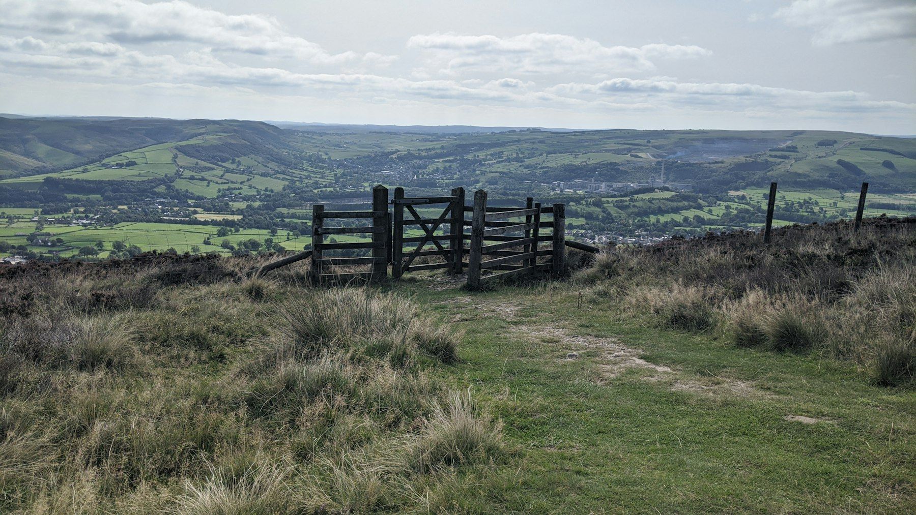 A wooden gate on top of a grassy hill
