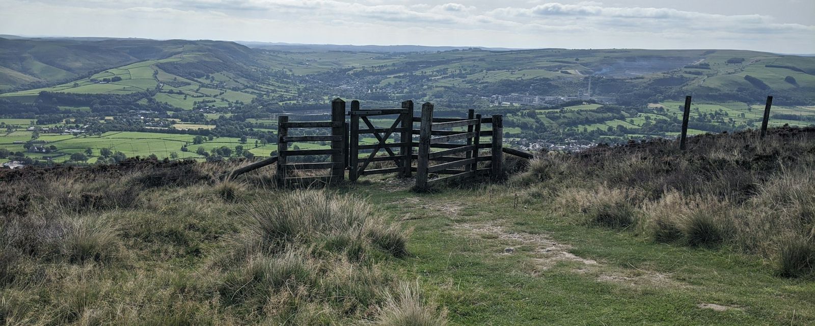 A wooden gate on top of a grassy hill
