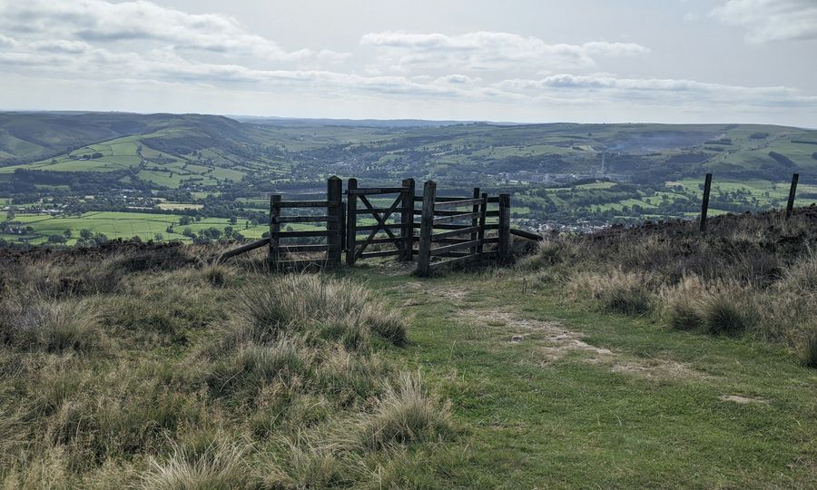 A wooden gate on top of a grassy hill