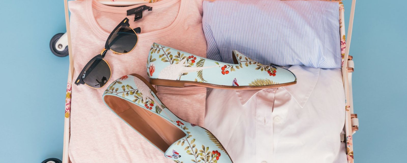 Clothing items and pair of shoes in luggage
