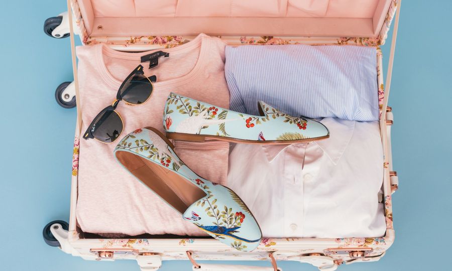 Clothing items and pair of shoes in luggage