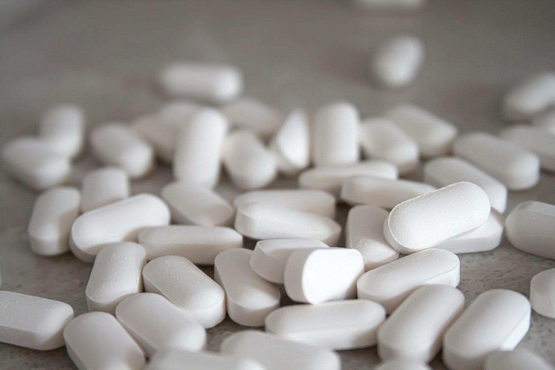 White medication pills on brown surface