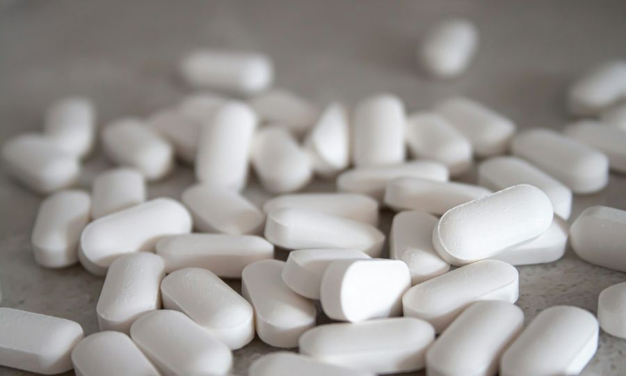 White medication pills on brown surface