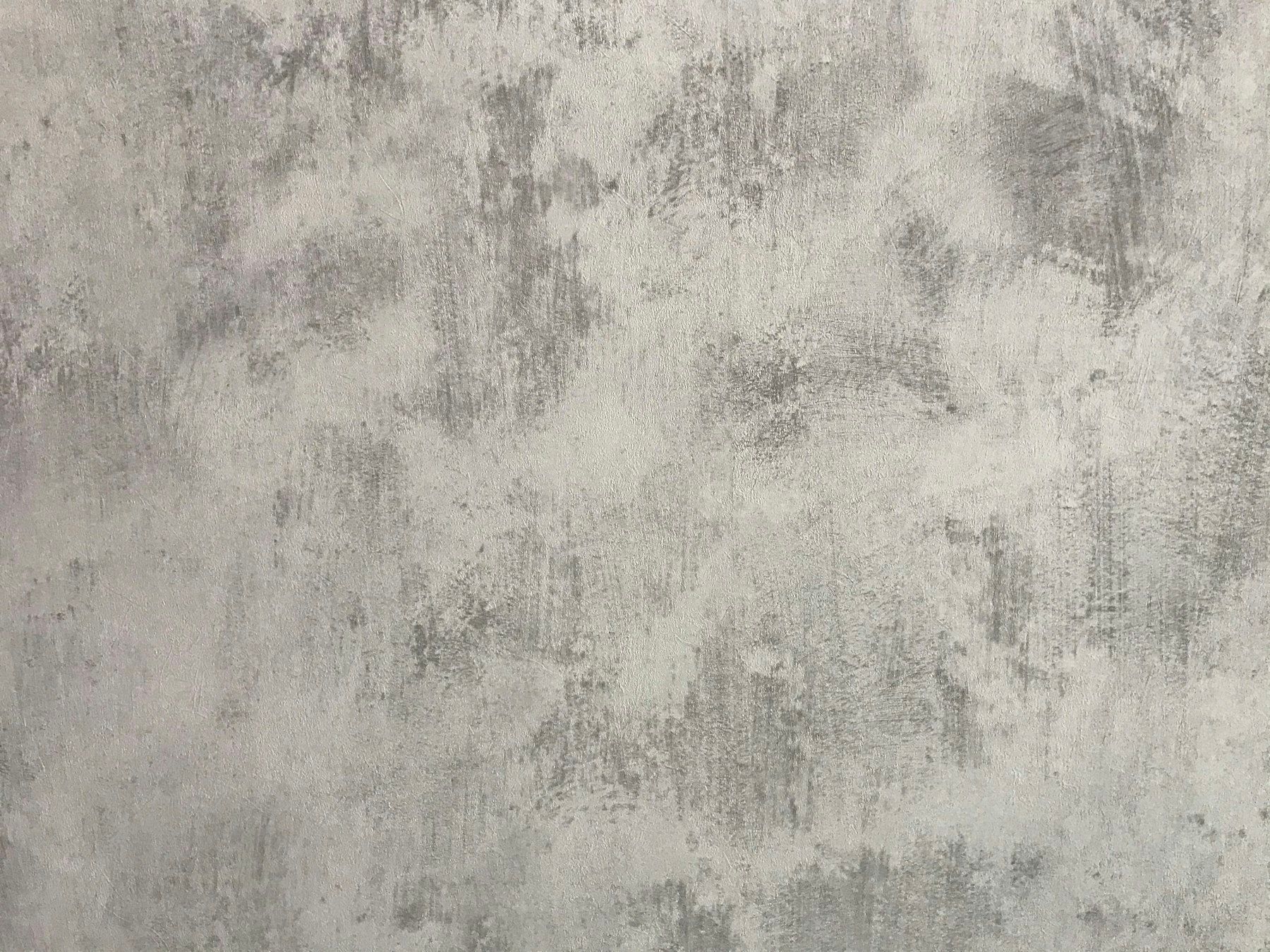 A grey wall with a mottled and distressed plaster texture