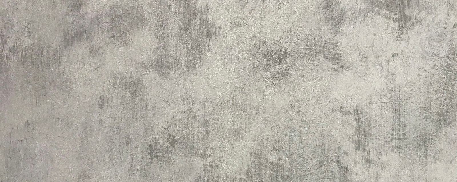 A grey wall with a mottled and distressed plaster texture