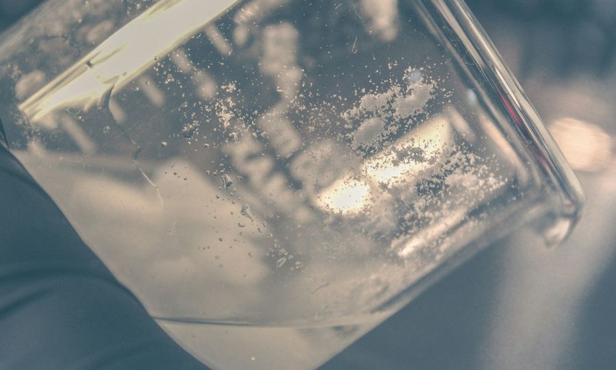 A person holding a glass with liquid in it