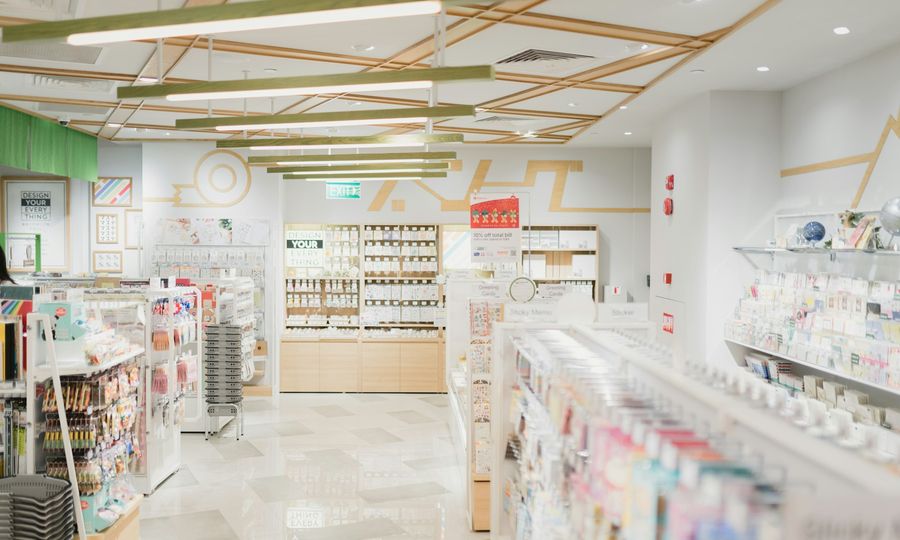 A bright stationery store interior with shelves of greeting cards and office supplies