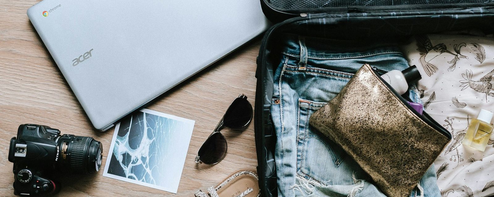 Black DSLR camera near sunglasses and bag