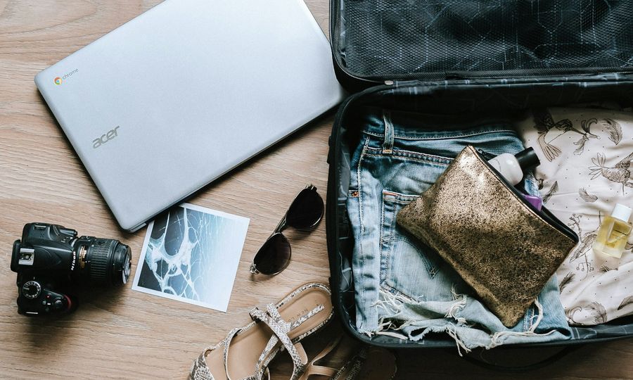 Black DSLR camera near sunglasses and bag
