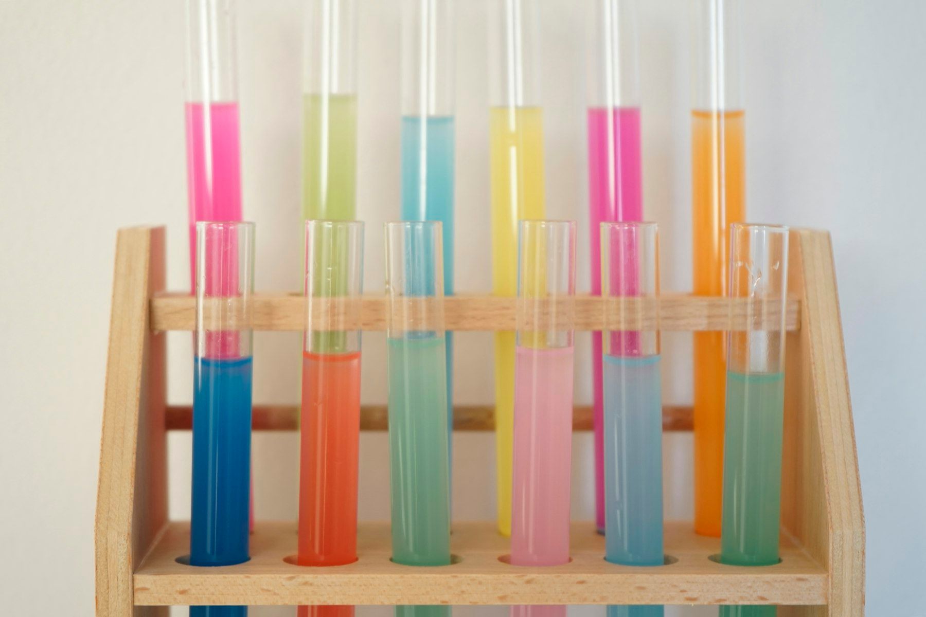 A wooden shelf filled with different colored liquids
