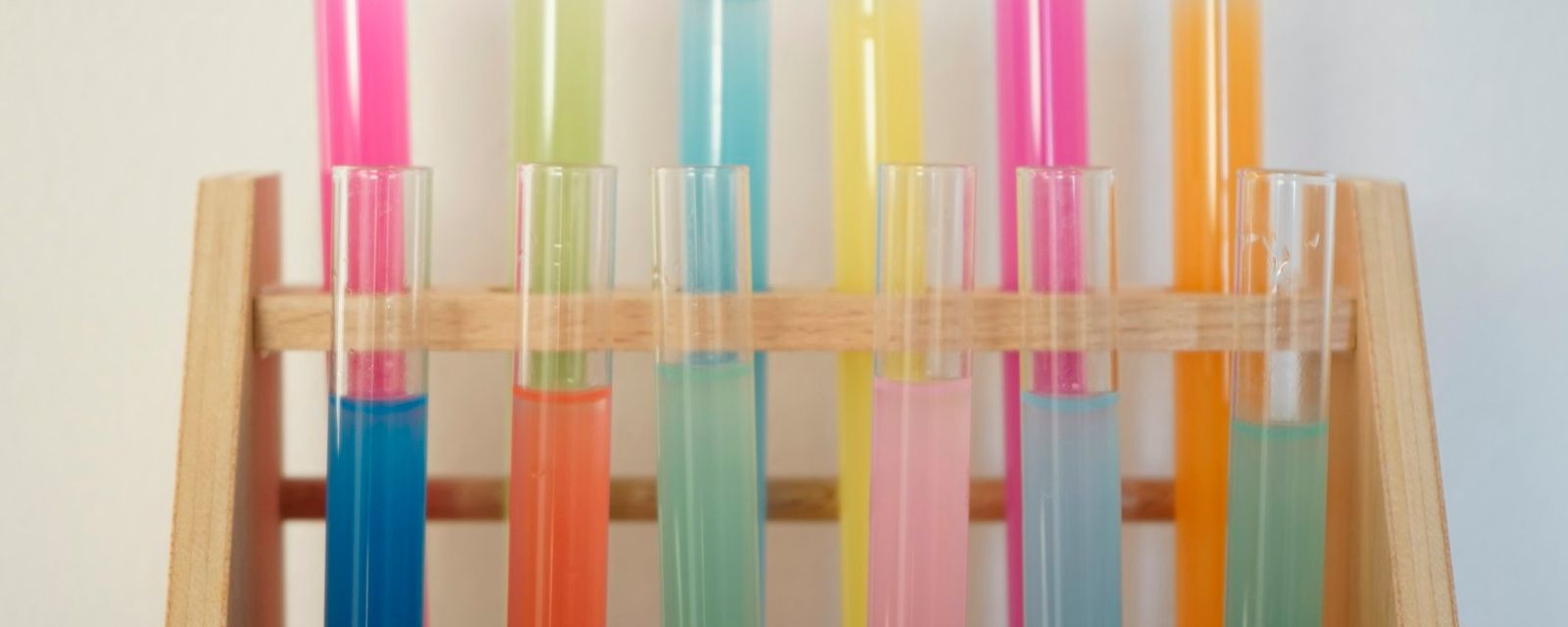 A wooden shelf filled with different colored liquids