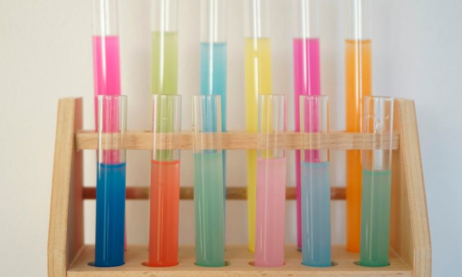 A wooden shelf filled with different colored liquids