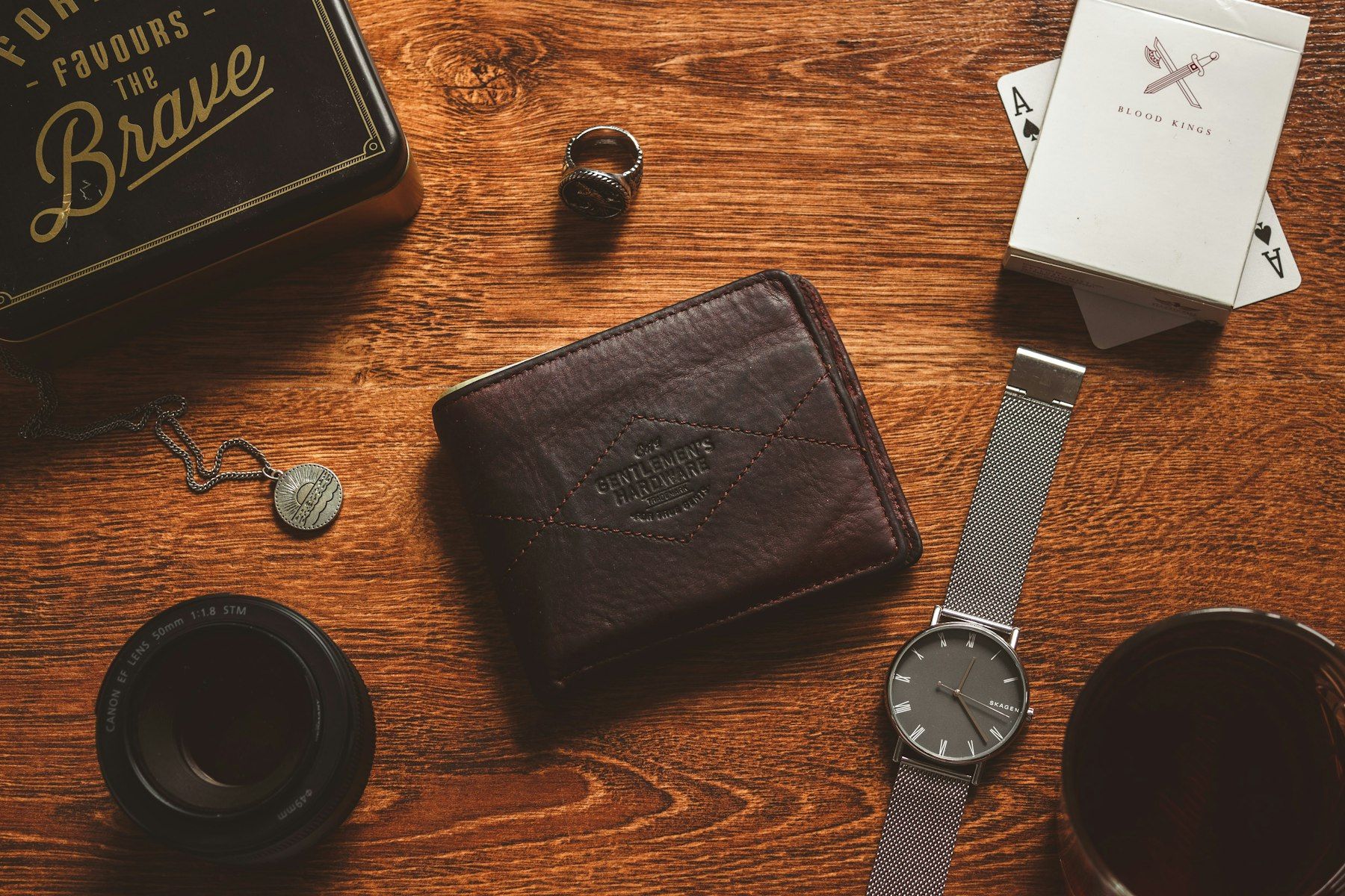 A wooden table topped with a wallet and a watch