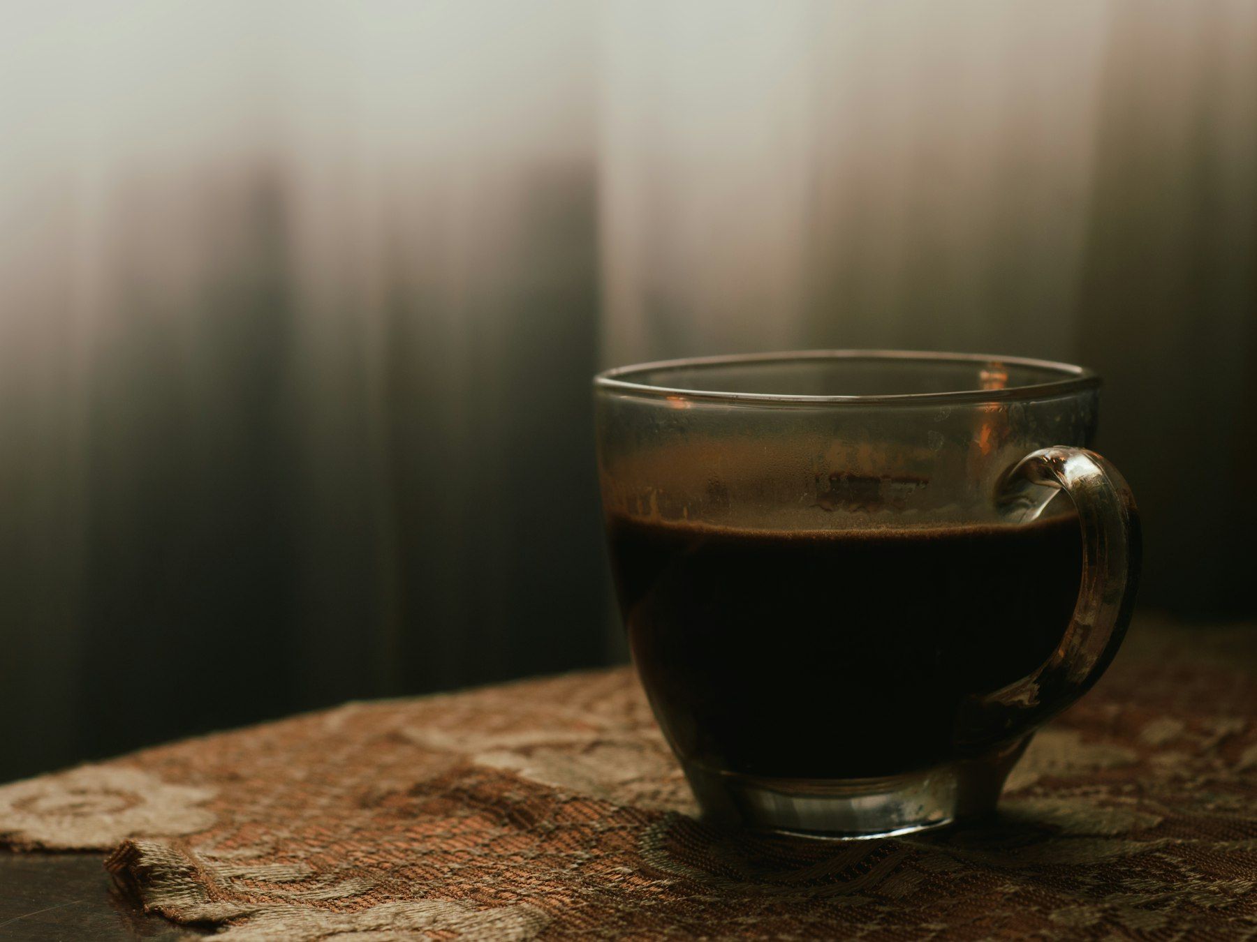 A cup of coffee sitting on top of a wooden table