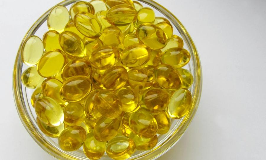A glass bowl filled with yellow glass beads